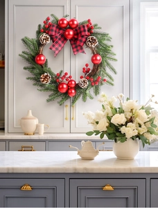 Detail of a 45cm Christmas wreath with red berries, pine cones and a buffalo plaid bow