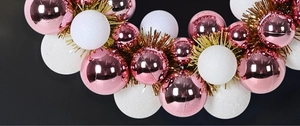 Detail of pink electroplated balls and white glitter ornaments on a Christmas wreath