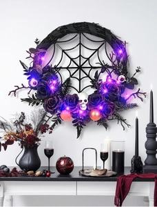 Detail of Halloween wreath with purple roses, skull, spider web and glowing LED lights