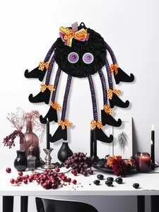 Detail of Halloween spider wall decor with striped legs and purple eyes on white background