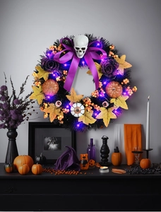 Macro detail of Halloween wreath with skeleton, purple LED lights, and pumpkins