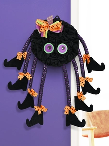 Detail of Halloween spider decoration with striped legs and colorful polka dot bows