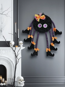 Close-up of a whimsical spider Halloween wreath with purple striped legs and wizard shoes