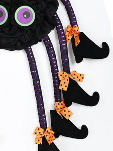 Close-up of Halloween witch legs wreath decoration with black mesh and orange polka dot bows