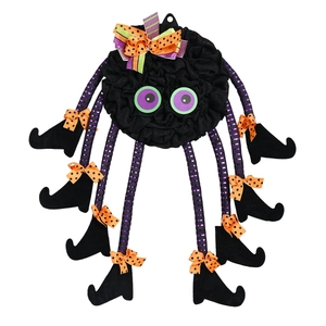 Quirky Halloween spider wreath decoration with purple eyes and striped legs on white backdrop