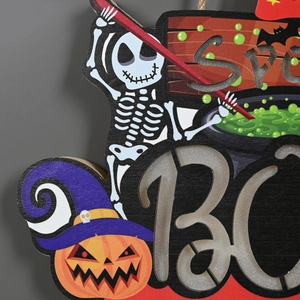 Detail of wooden Halloween BOO sign featuring pumpkin and witch cauldron with glitter