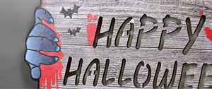 Détail de plaque Halloween en bois avec mains de zombies et motifs de chauve-souris