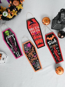 Detail of four coffin-shaped Halloween wooden signs with festive motifs and hanging ropes