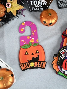 Close-up of pumpkin Halloween door hanger with festive candy corn patterns
