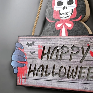 Close-up of wooden Happy Halloween door sign with skull and bat detail on a grey wall
