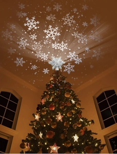Dynamic snowflake projection from silver star tree topper onto ceiling in warm home setting