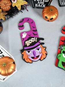Detail of purple Halloween door hanger with cartoon witch and BOO text on glitter background