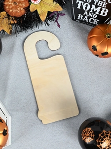 Macro view of unpainted wooden door hanger with natural grain for Halloween DIY crafts
