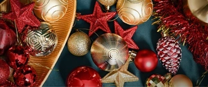 Close-up of red and gold Christmas ornaments with glitter, pinecones and star tree decorations