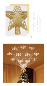Detail der goldenen Glitzer-Stern-Christbaumspitze mit weißer Schneeflocken-Projektion