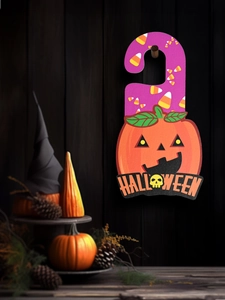 Close-up of wooden Halloween door hanger with pumpkin and candy motifs on wood backdrop