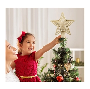 Goldener Glitzer-Stern als Weihnachtsbaumspitze wird von einem Kind aufgesetzt