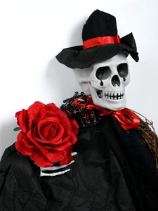 Gros plan d'un marié squelette d'Halloween avec chapeau noir et une rose rouge vive