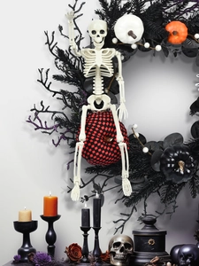 Halloween decor set with poseable skeleton, black wreath, and plaid pumpkin on white wall