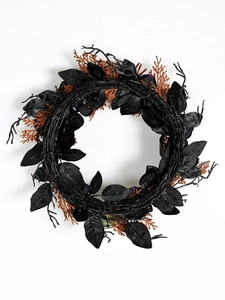 Detail of Halloween wreath featuring black faux foliage and glittery orange branch accents