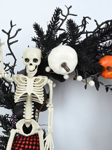 Detailed view of Halloween wreath with white skeleton and orange pumpkins on black twigs
