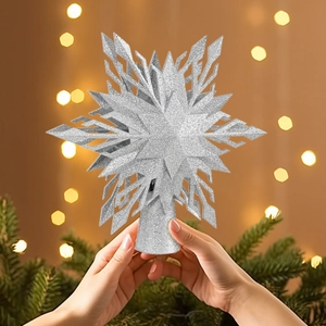 Silver snowflake tree topper with glitter finish held in hands for holiday decoration