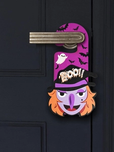 Detail of purple Halloween door hanger featuring a cartoon witch and BOO text on wood