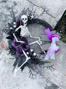 Dettaglio ghirlanda di Halloween con teschio, rose glitter viola e fiocco a scacchi