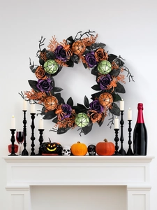Halloween wreath with purple roses and glitter baubles hanging over a white fireplace