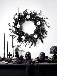 Macro detail of gothic Halloween wreath with black twigs and white pumpkins on a wall