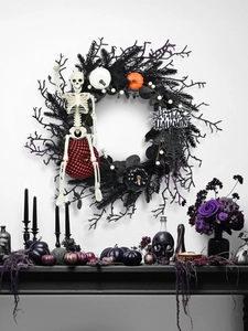 Close-up of Halloween wreath with black twigs, skulls, pumpkins and a Happy Halloween sign