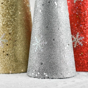 Close-up of glittery Christmas cone ornaments with snowflake prints and silver sequins