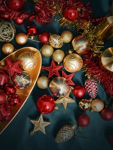 Close-up of red and gold Christmas ornaments with textured balls and pinecones