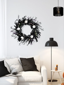 Gothic Halloween wreath with white pumpkins displayed on a modern living room wall