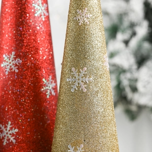 Macro shot of glittery gold and red Christmas cone ornaments with white snowflake details