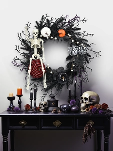Detail of Halloween wreath with skeleton, colorful pumpkins and Happy Halloween sign