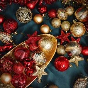 Red and gold Christmas tree ornaments set with star tree topper on silk background