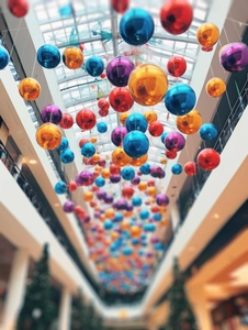 Colorful glossy Christmas ornaments hanging in a mall with bright reflective finishes