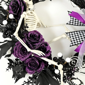 Ghirlanda di Halloween con scheletro, rose glitterate viola e fiocco pied de poule