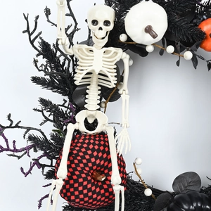 Halloween wreath with white skeleton, checkered pumpkin, and black branches for party decor