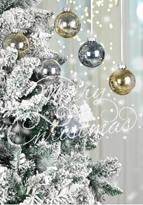 Detail of silver and champagne Christmas ornaments on a snowy tree with bokeh lights