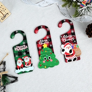 Close-up of three wooden Christmas door hangers with plaid patterns and festive characters
