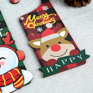 Detail of Christmas buffalo plaid wooden tags with reindeer and snowman on silver background