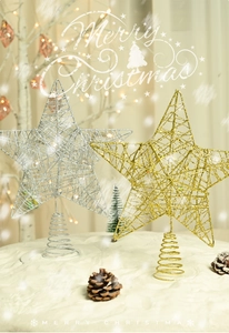 Detail of glittered iron star tree topper with spiral base in festive holiday scene