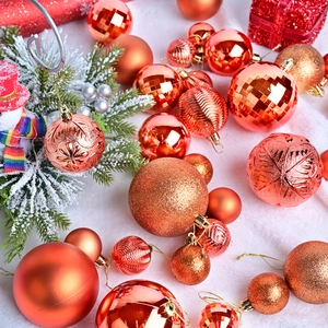Copper and orange Christmas ball ornaments with matte and glitter finishes on white fur