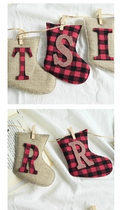 Close-up of Christmas stocking banner with plaid fabric, letters and wooden clips on rope