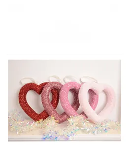 Detail of glitter heart ornaments in red and pink gradients with white ribbons