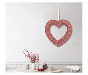 Close-up of glittery pink heart pendant hanging on a white wall for Valentine decor