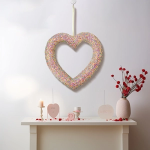 Glitzernder roter Herzkranz an weißer Wand als Valentinstag-Partydekoration für zu Hause