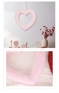 Detail of pink heart-shaped wreath with textured glitter finish and cozy home decor scene